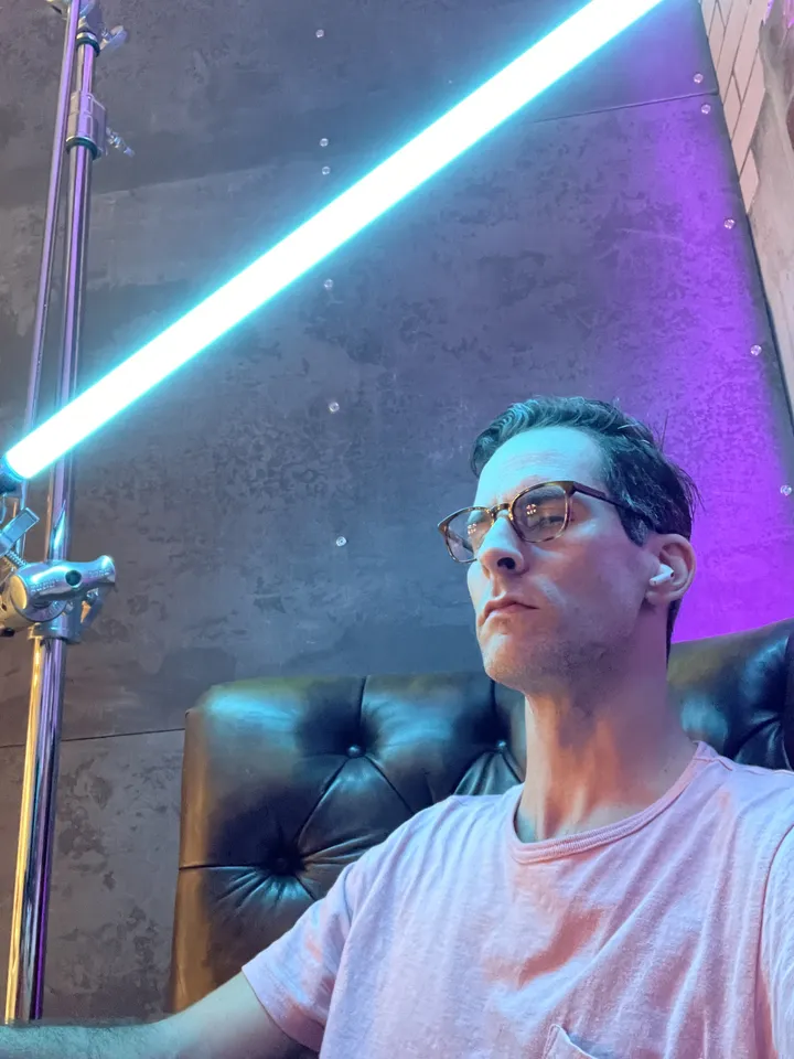 Joel Harrison, portrait lit in cyan and magenta neon